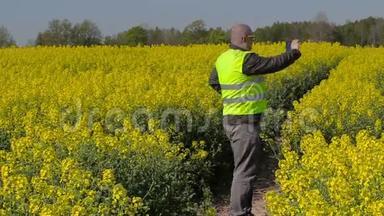 农民用智能手机拍照，在田里散步